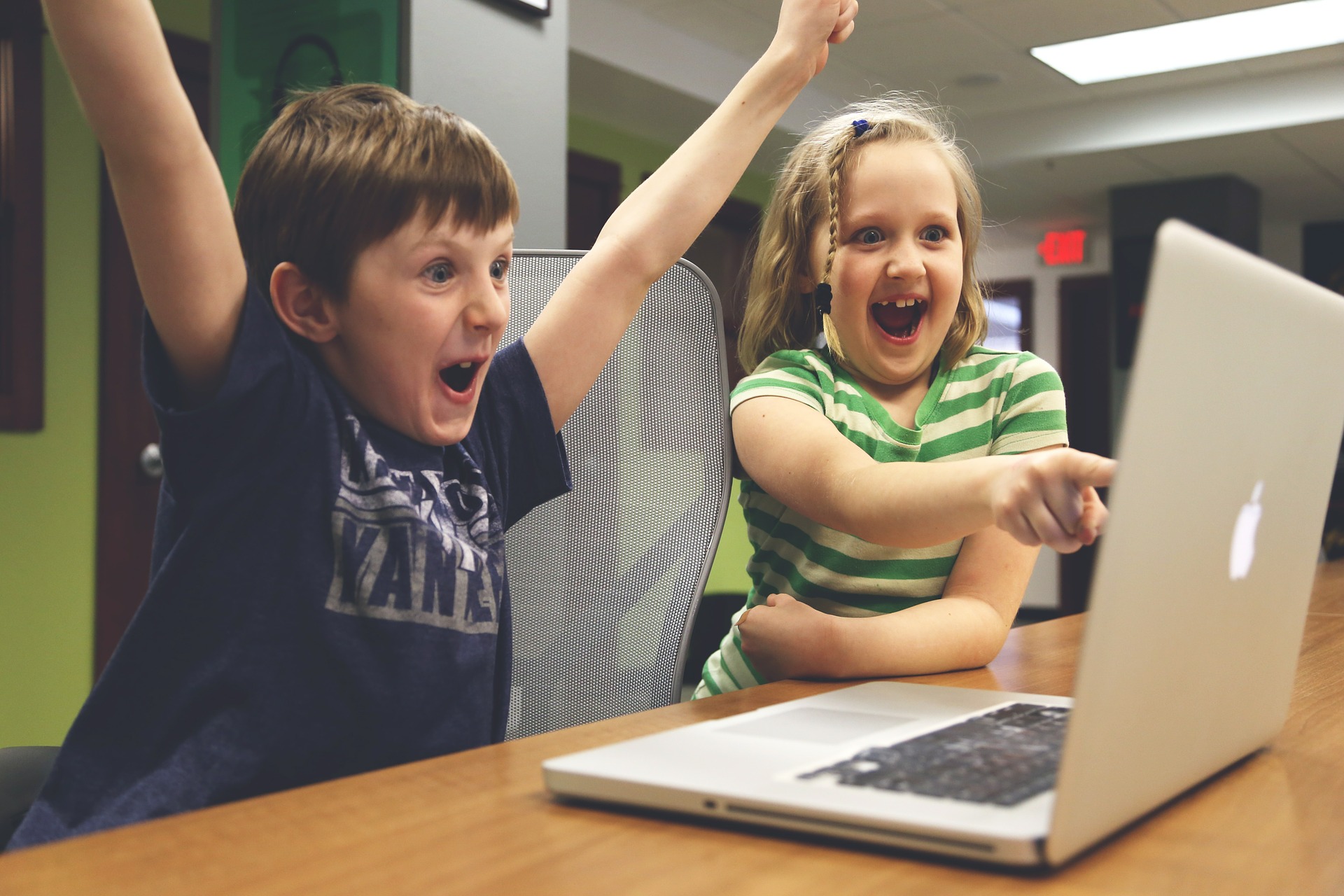 children cheering and pointing at computer screen